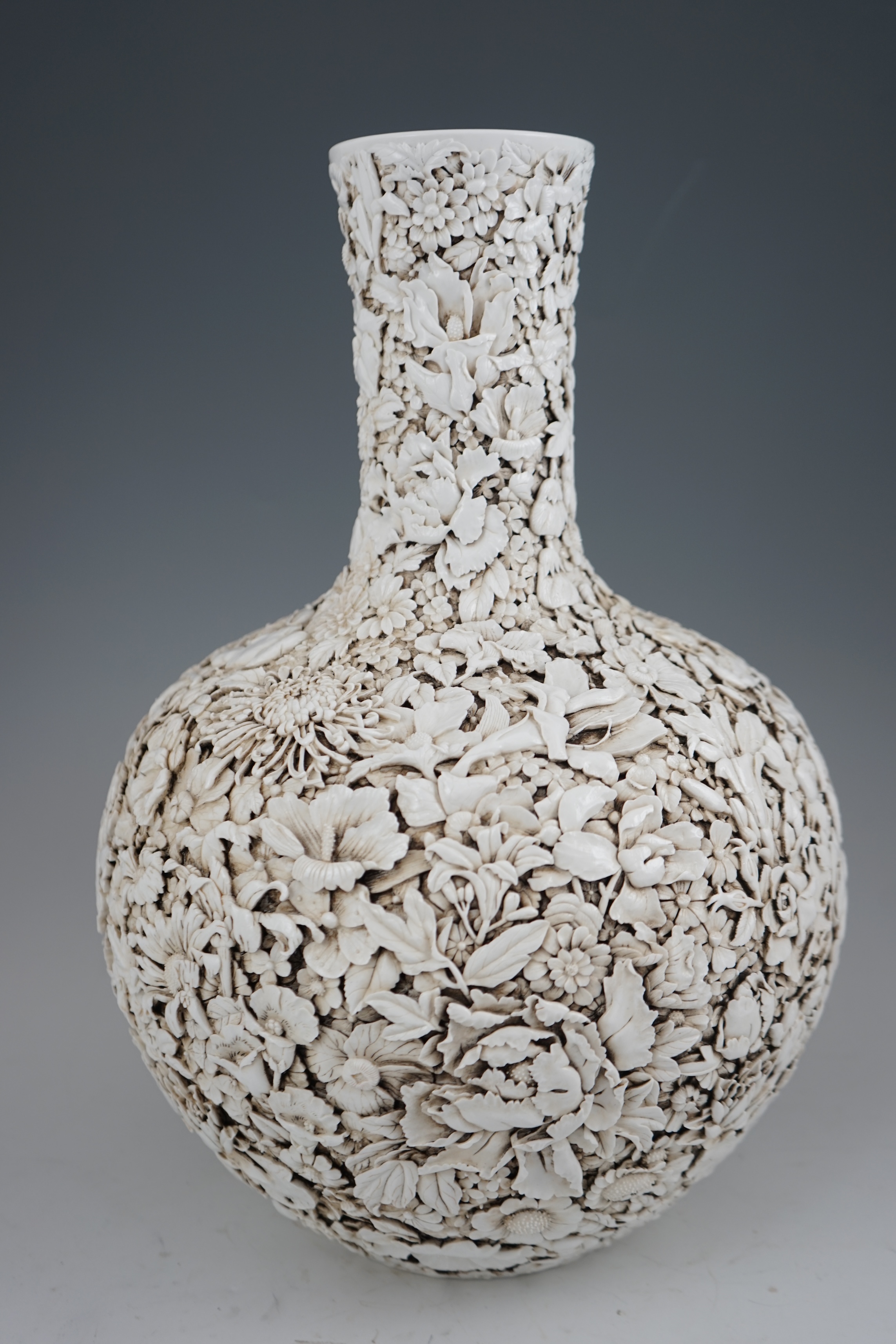 A large Chinese carved porcelain ‘thousand flower’ bottle vase, 20th century